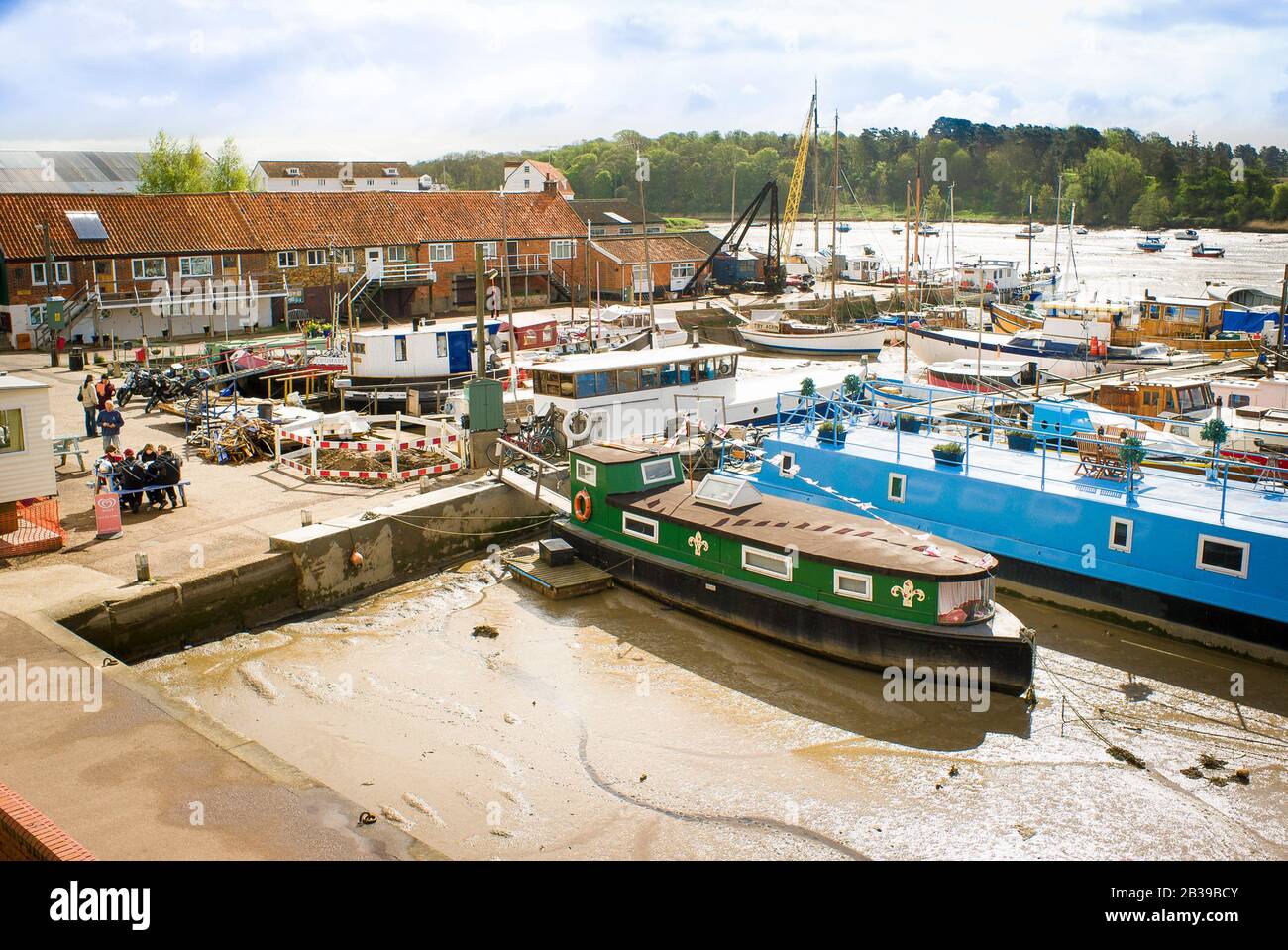 La bassa marea lascia piccole barche bloccate nel porto di Woodbridge sul fiume Deben nel Suffolk Inghilterra UK Foto Stock