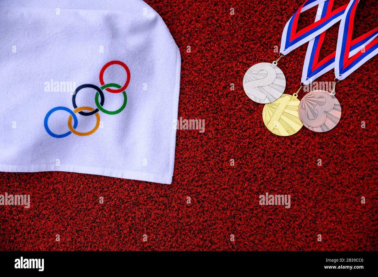 TOKYO, GIAPPONE, 5 MARZO. 2020: Set di medaglie e anelli olimpici, pista di atletica rossa in background Foto Stock