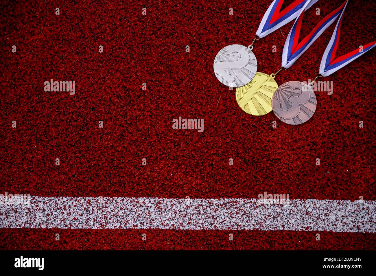 Medaglia set al tracciato di atletica rossa, vittoria, foto di concetto di successo sportivo, spazio di editazione rosso Foto Stock