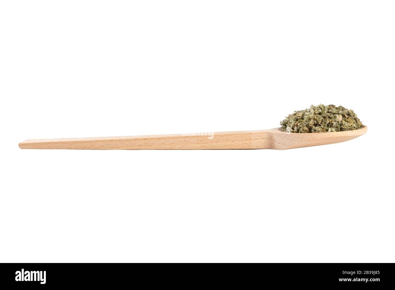 Foglie di carciofo essiccate o in latino Cynarae folium in cucchiaio di legno isolato su sfondo bianco. Erbe curative medicinali. Medicina a base di erbe. Alternativa Foto Stock