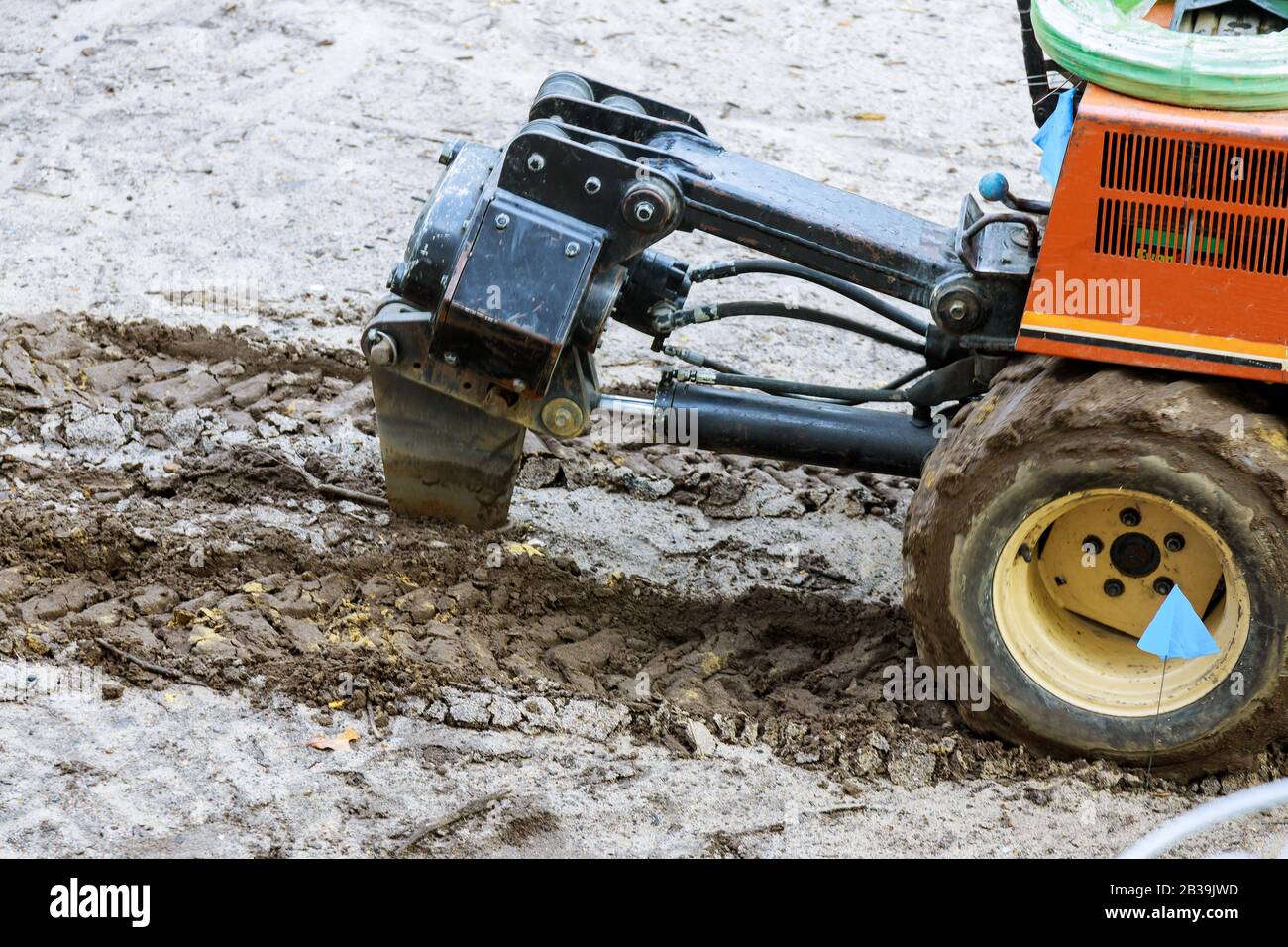 Lo scavo di un tubo in lavoratori installazione di irrigazione per annaffiare le piante con impianto di irrigazione automatico. Foto Stock