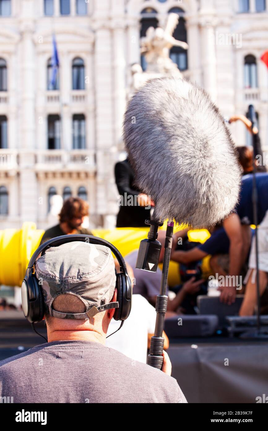 Dietro la scena. Registratore audio con microfono, microfono con asta portamicrofono e cuffie per filmare la scena cinematografica all'aperto Foto Stock