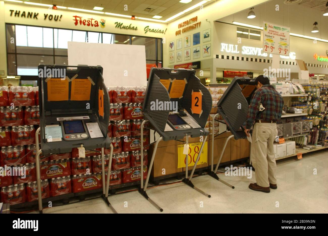 Austin, Texas USA, 3 marzo 2004: Texans esercitandosi presto votando ad un deposito della drogheria di Fiesta in Austin orientale sulle nuove macchine elettroniche di voto. © Bob Daemmrich Foto Stock