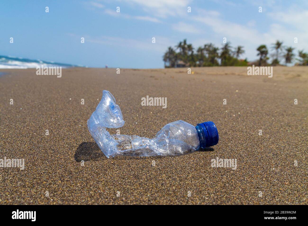 Primo piano bottiglia vuota di rifiuti di plastica sulla spiaggia del mare. Foto Stock
