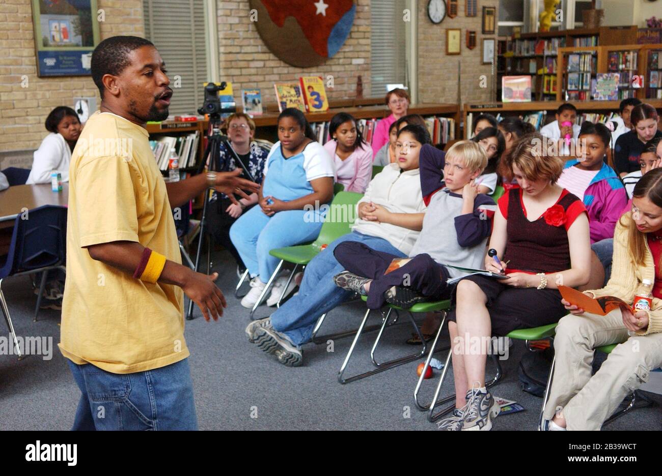 Austin Texas USA, circa 2004: Black Poet spiega le regole di concorrenza prima dell'inizio del primo 'Slam Poetry' per gli studenti di 7° grado alla Fulmore Junior High School nella biblioteca della scuola. ©Bob Daemmrich Foto Stock