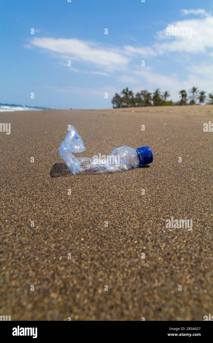 Primo piano bottiglia vuota di rifiuti di plastica sulla spiaggia del mare. Foto Stock