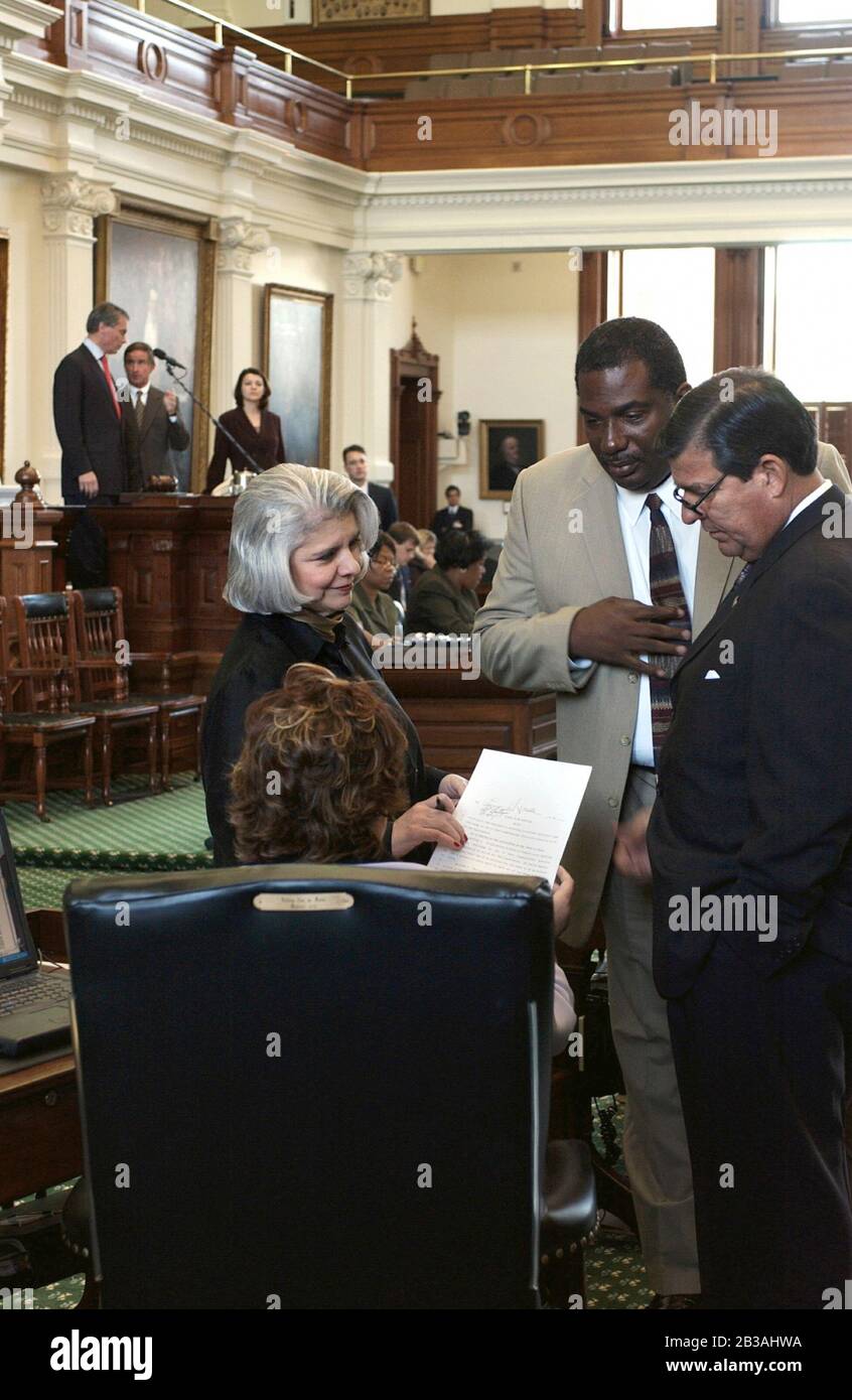 Austin, Texas USA, 21 luglio 2003: Sessione speciale della Legislatura del Texas per considerare un disegno di legge di riorganizzazione controverso inteso per dare più di una maggioranza repubblicana al Congresso degli Stati Uniti. Lo sforzo è stato guidato dietro le quinte dal rappresentante degli Stati Uniti, Tom Delay. Nella foto si trovano il Sen. Judith Zaffasini (l) (D-Laredo) che parla con il Sen. Royce West (centro) (D-Dallas) e il Sen. Eddie Lucio (r) (D-Brownsville). ©Bob Daemmrich Foto Stock