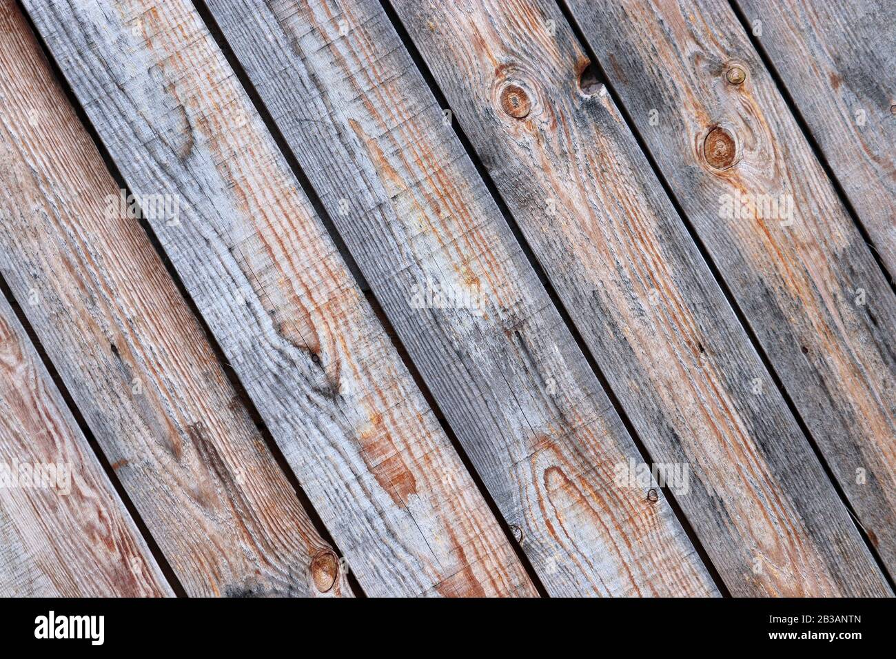 Parete in legno, pannelli marroni non dipinti. Pannelli diagonali vecchi texture con nodi per sfondo Foto Stock