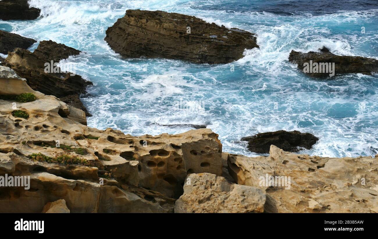 Costa del mare con onde che si infrangono sulle rocce Foto Stock