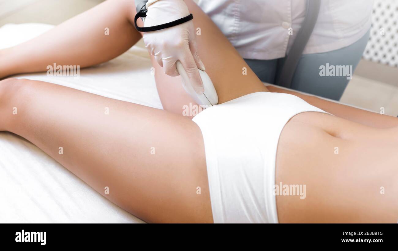 Rimozione dei peli laser sulla pelle delle gambe. Epilazione in un salone di bellezza. Foto Stock