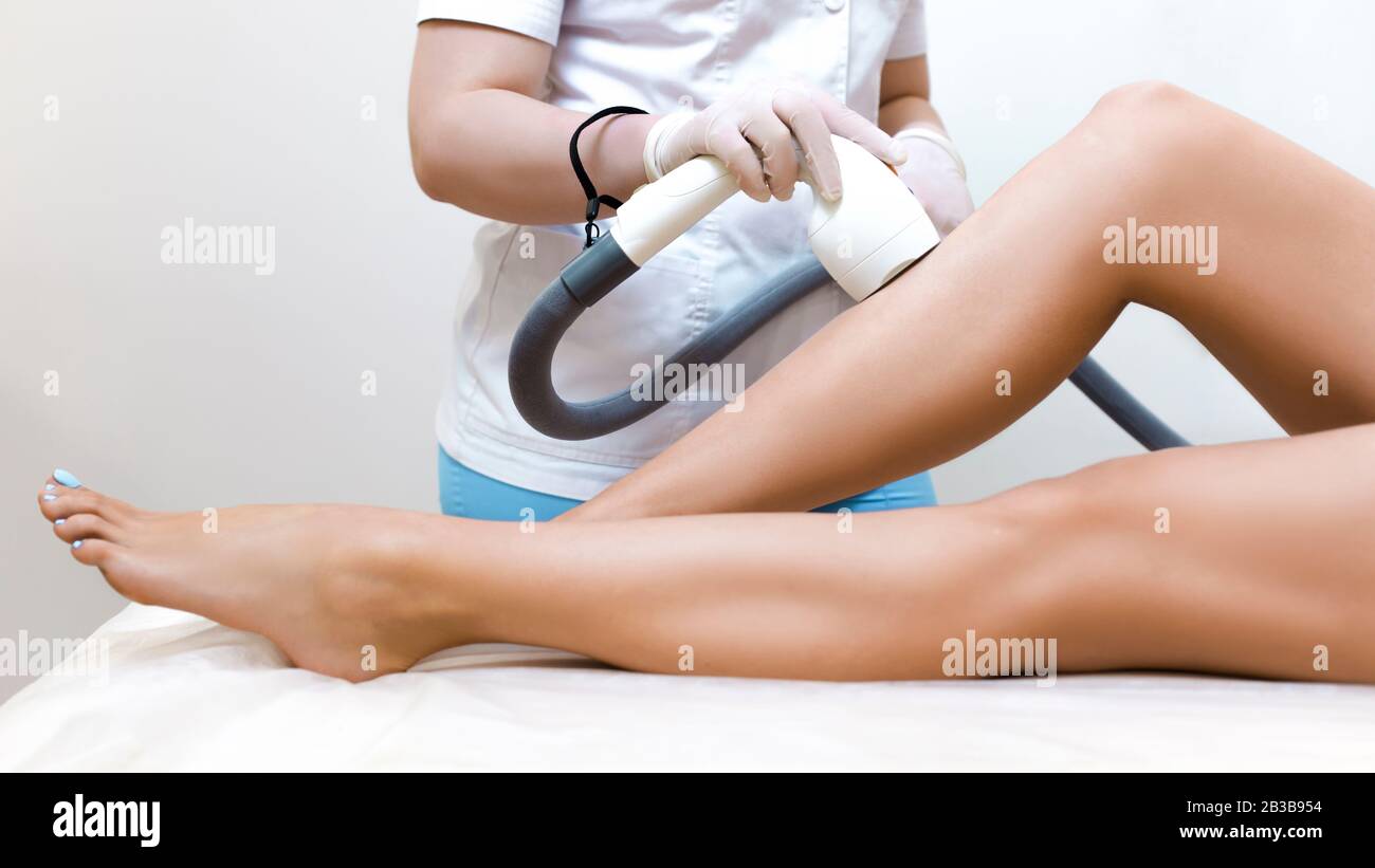 Rimozione dei peli laser sulla pelle delle gambe. Epilazione in un salone di bellezza. Foto Stock