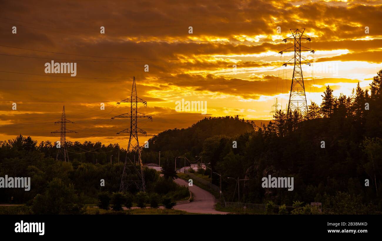 Saguenay, Canada - 14 agosto 2019: Saguenay Valley Golden Sunset vista con la silhouette della torre del cavo di alimentazione elettrica vicino alla città di Saguenay Foto Stock