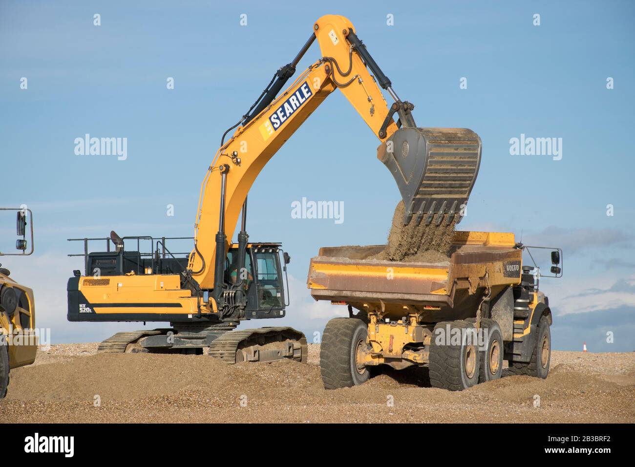 Hayling Island, Hampshire. Macchine movimento terra è usato per spostare ghiaia spiaggia da ovest ad est ogni anno per contrastare l'effetto di deriva longshore Foto Stock