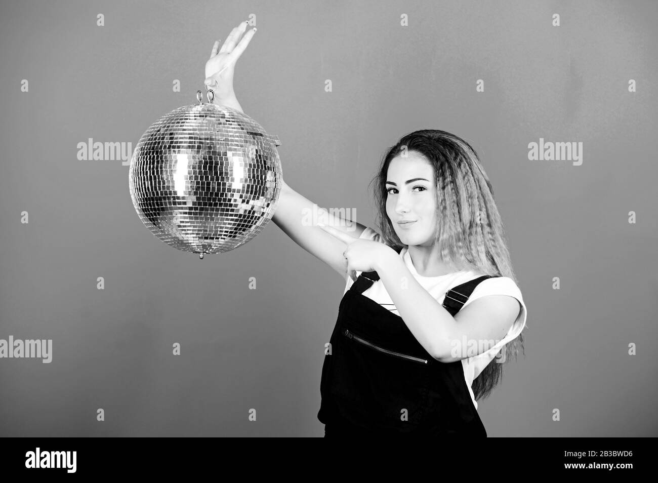 Invito alla festa. Ragazza di compleanno. Gli specchi riflettenti discoteca luci di atmosfera. Concorso di ballo. Scuola di ballo. Allegro woman dancing insegnante tenere palla da discoteca. Come circa la parte. Night club. Musica retrò. Foto Stock