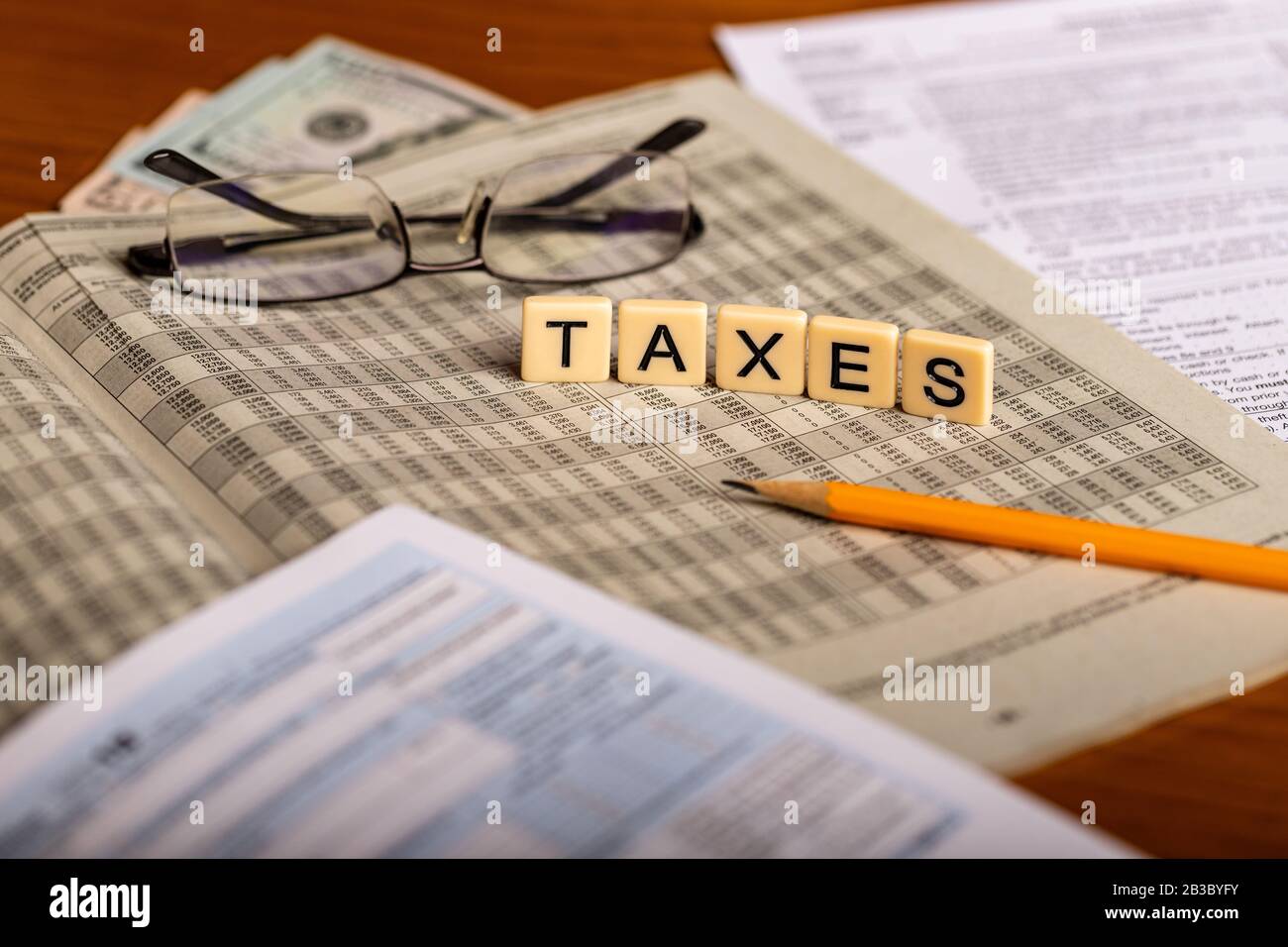 Immagine concettuale delle forme fiscali con occhiali, soldi e matita Foto Stock