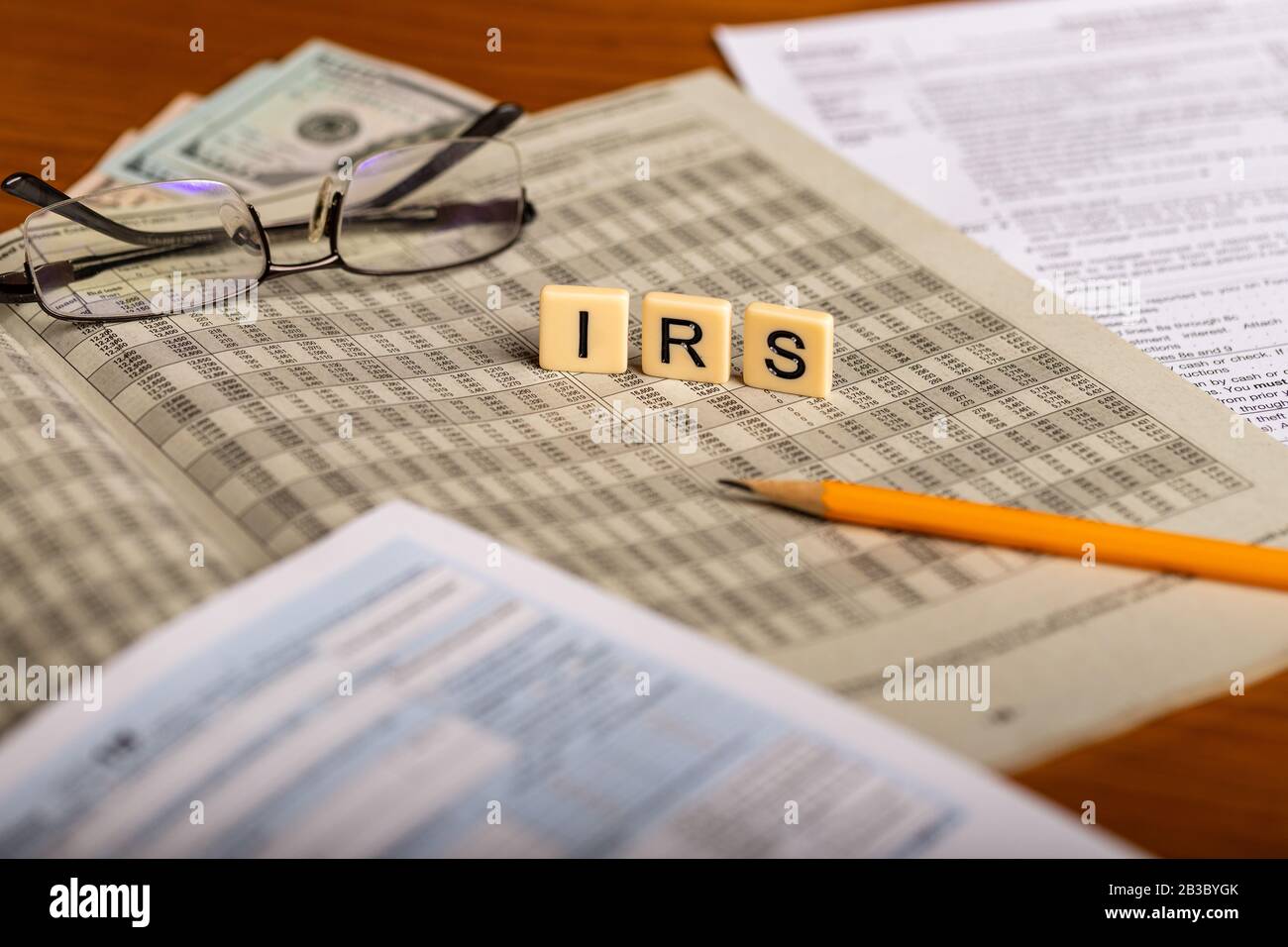 Immagine concettuale delle forme fiscali con occhiali, soldi e matita Foto Stock