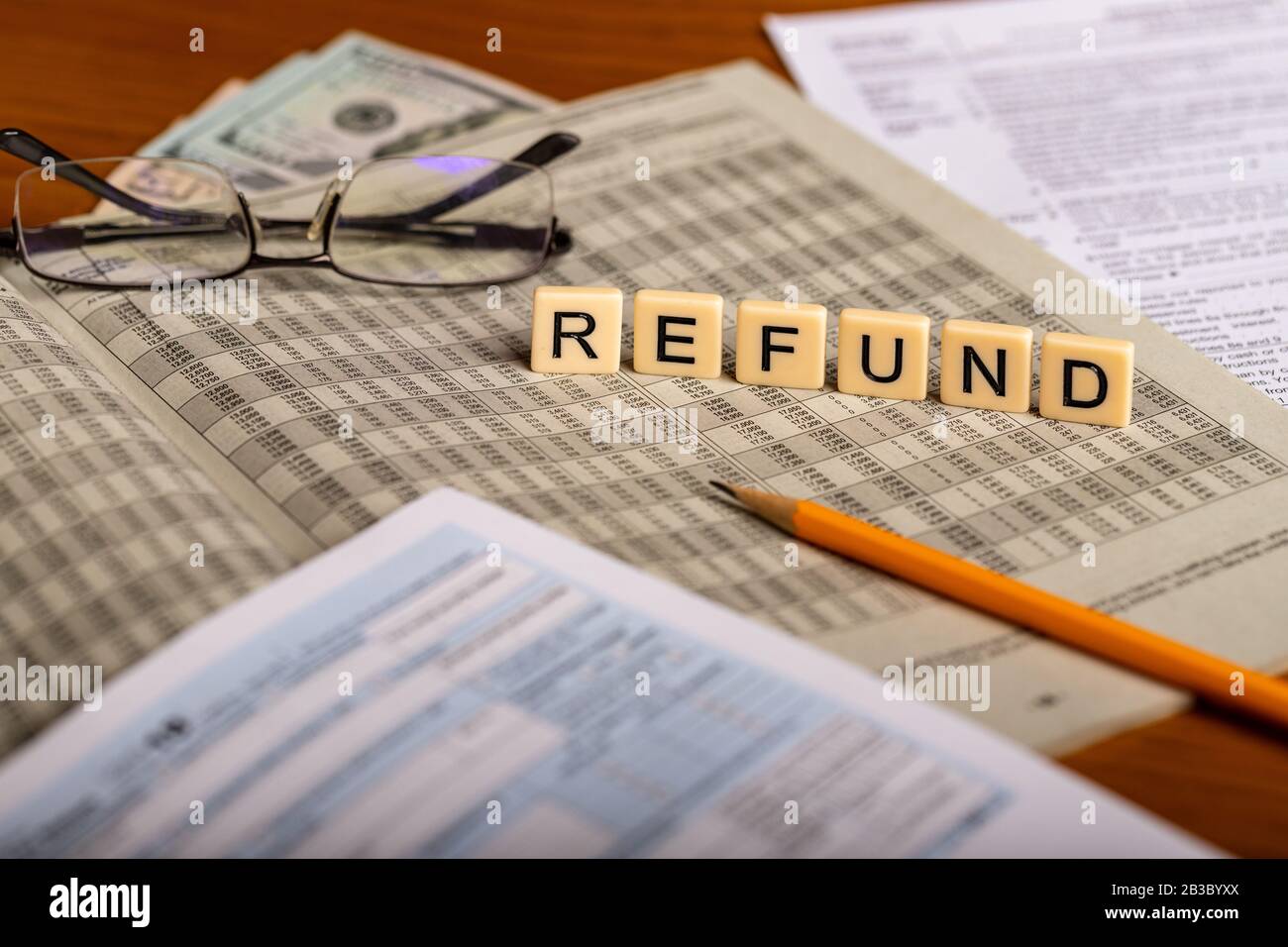 Immagine di concetto o rimborso fiscale con forme, matita, occhiali e soldi Foto Stock
