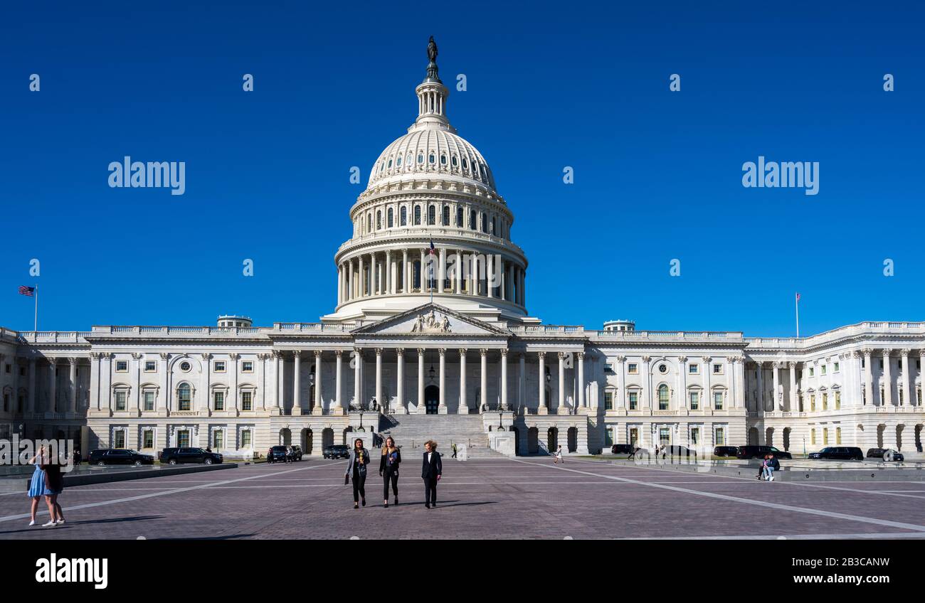 Washington, DC, USA -- 4 marzo 2020. Tre donne camminano nella plaza di fronte al Capitol Building che si staglia dietro di loro. Foto Stock