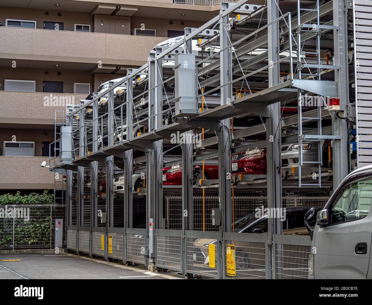 Un sistema creativo che utilizza la tecnologia per impilare e parcheggiare le auto in un'area urbana affollata. Foto Stock