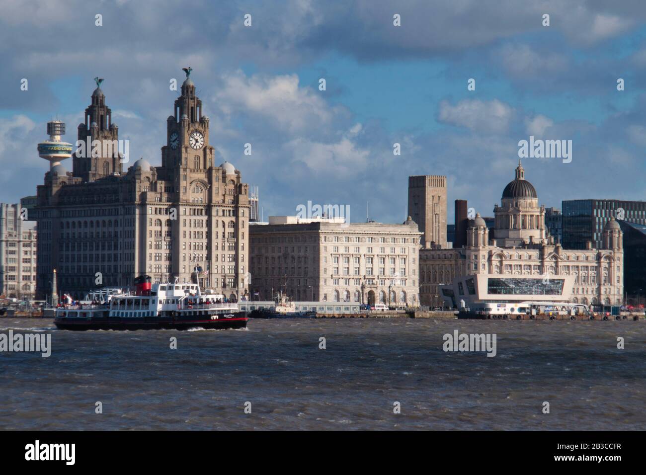 Il Mersey Ferry Royal Iris passa Le Tre grazie sul lungomare storico di Liverpool, patrimonio dell'umanità dell'UNESCO, in una giornata di sole Foto Stock
