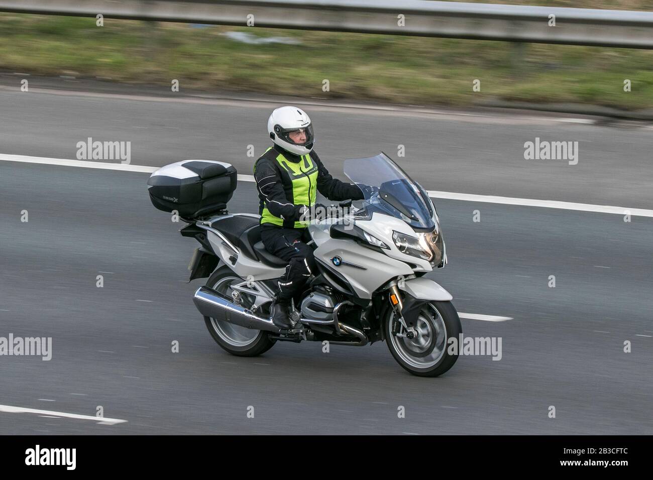 Moto BMW e pilota in sella all'autostrada M6 vicino a Preston in Lancashire, Regno Unito Foto Stock