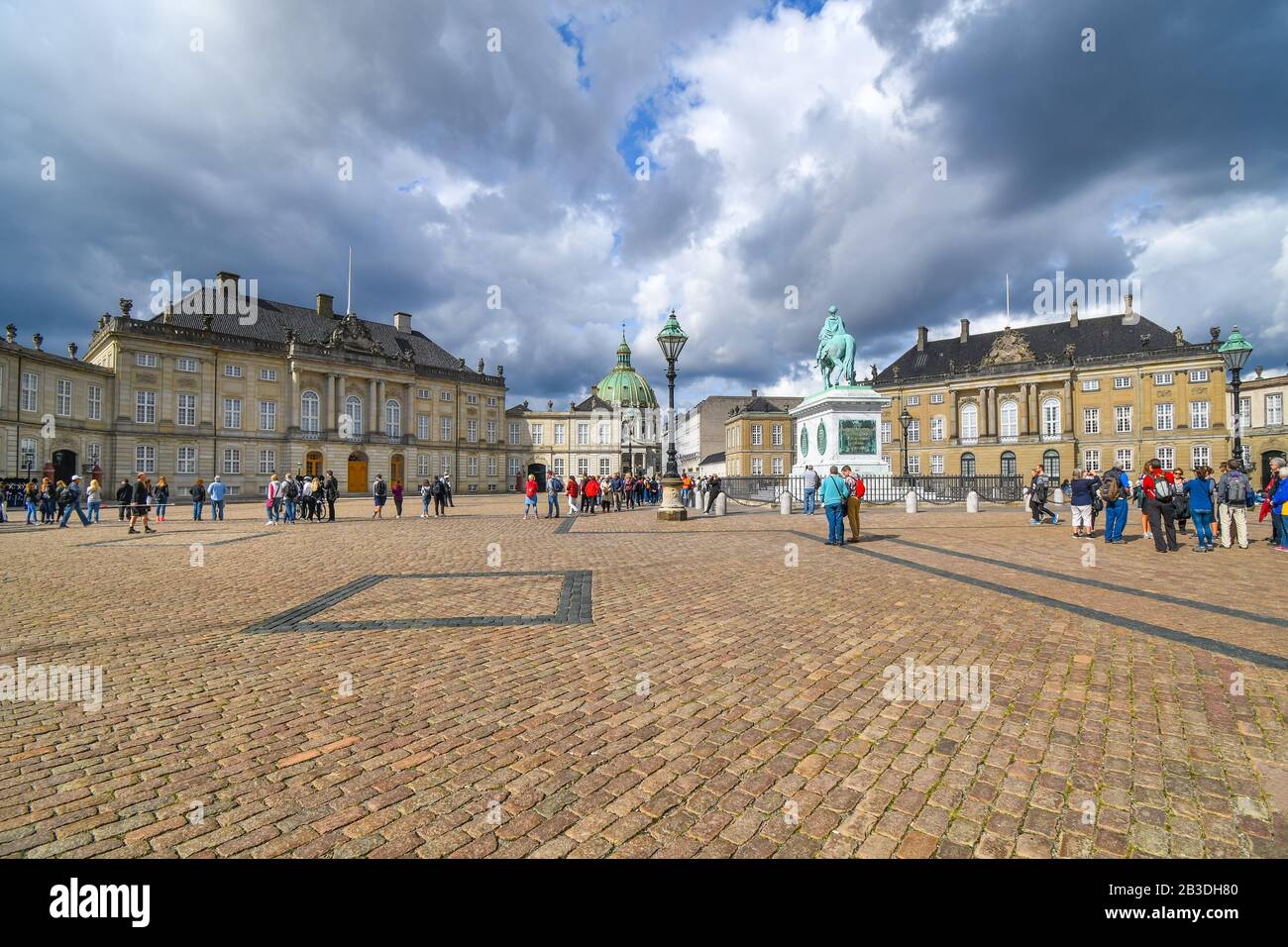 I turisti visitano la piazza principale del Palazzo di Amalienborg con la Chiesa di marmo di Frederik e la statua equestre in vista. Foto Stock