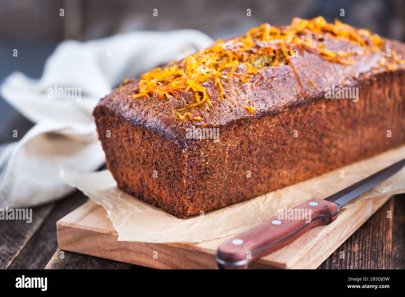 Deliziosa torta di pane fatta in casa con semi di papavero e arancia su sfondo rustico in legno Foto Stock