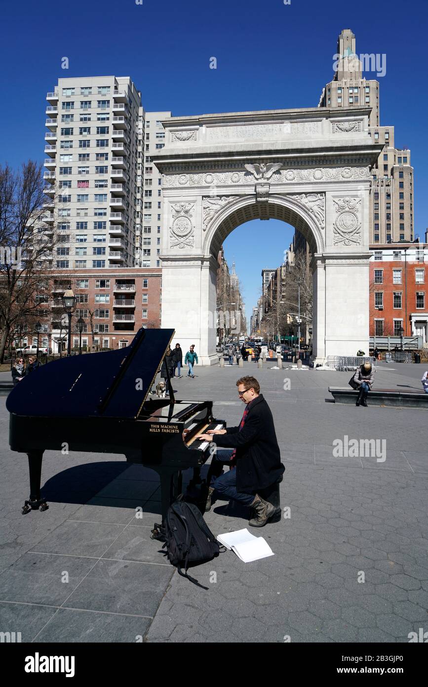 Un pianista che suona un pianoforte a coda con Wood Guthrie's. Dicendo questa macchina uccide i fascisti scritti su di essa .Washington Square Park.New York City.USA Foto Stock