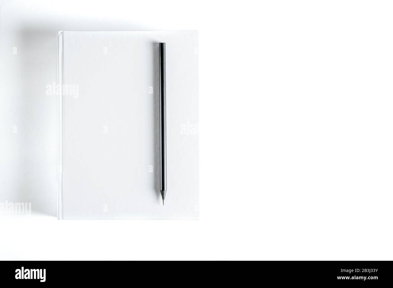 Mockup di libro quadrato vuoto chiuso e matita nera su sfondo carta testurizzato colorato. Copertina Rigida Mock-Up - Custodia Antipolvere. Parete Di Fondo Foto Stock
