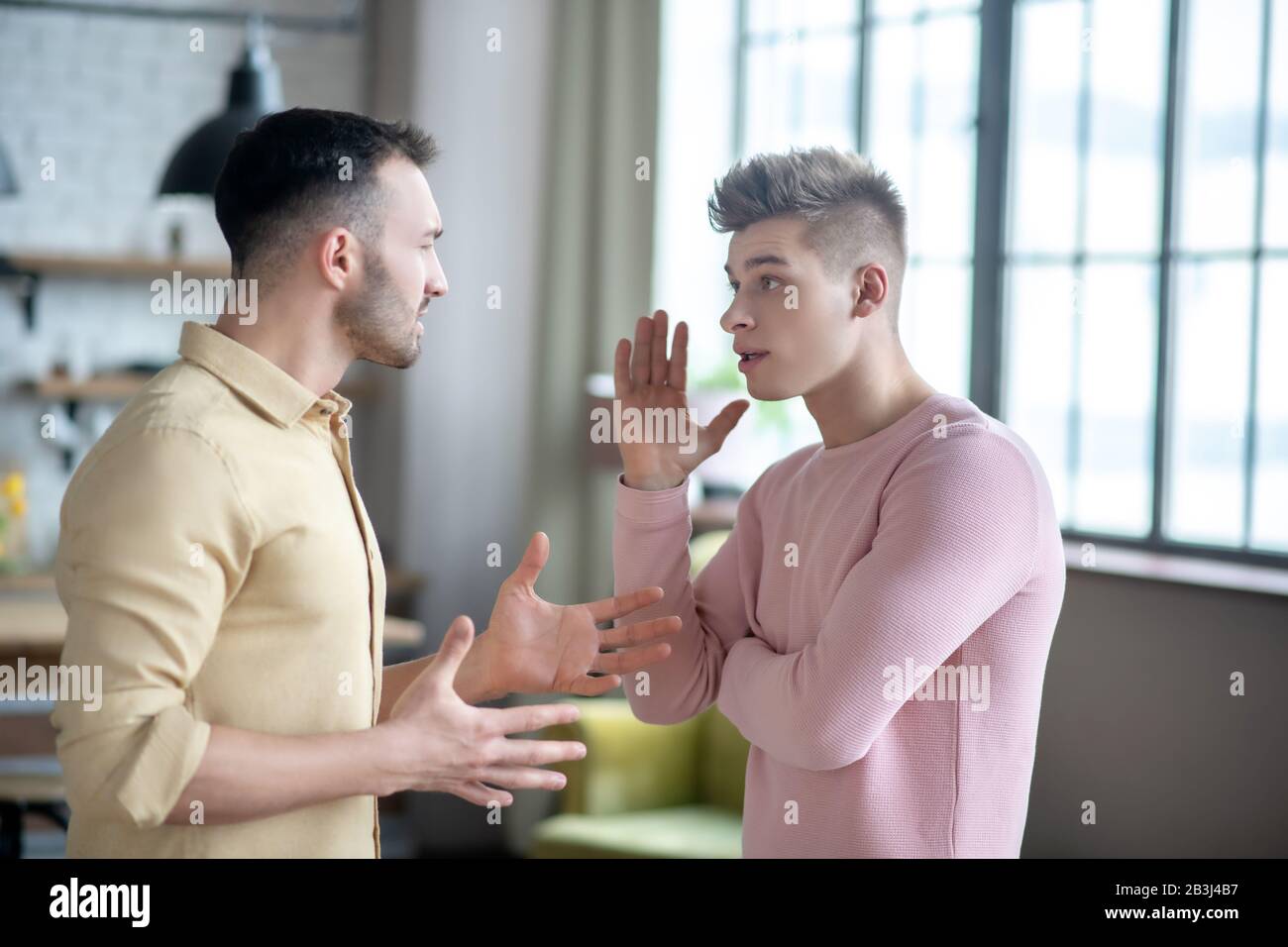 Due giovani uomini che hanno un argomento e guardare eccitato Foto Stock