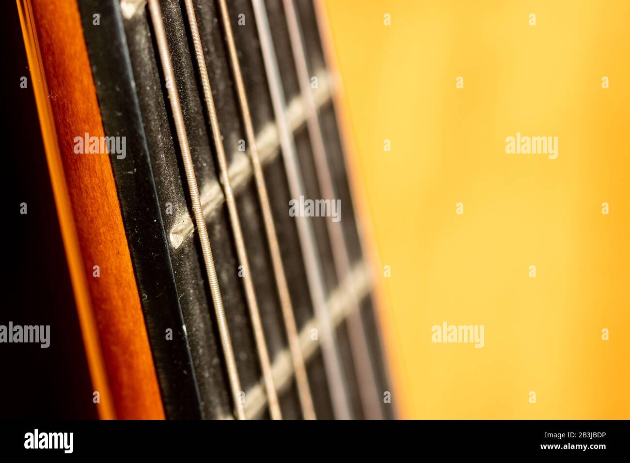 Fuoco selettivo sulle corde della chitarra acustica alla luce del sole del mattino Foto Stock