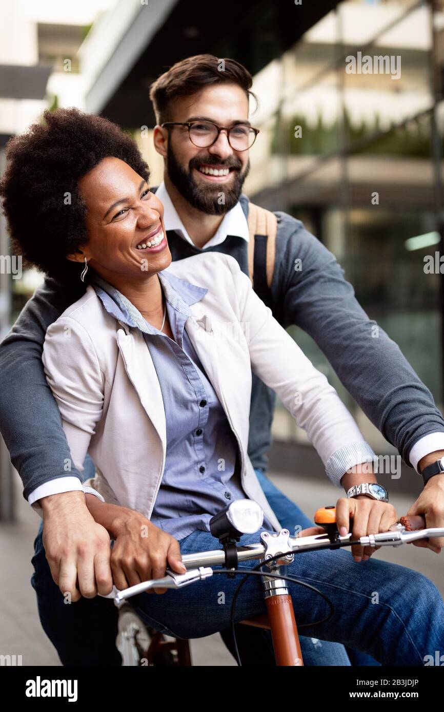 Gente allegra che va per un giro in bicicletta. Buona coppia divertirsi in città. Foto Stock