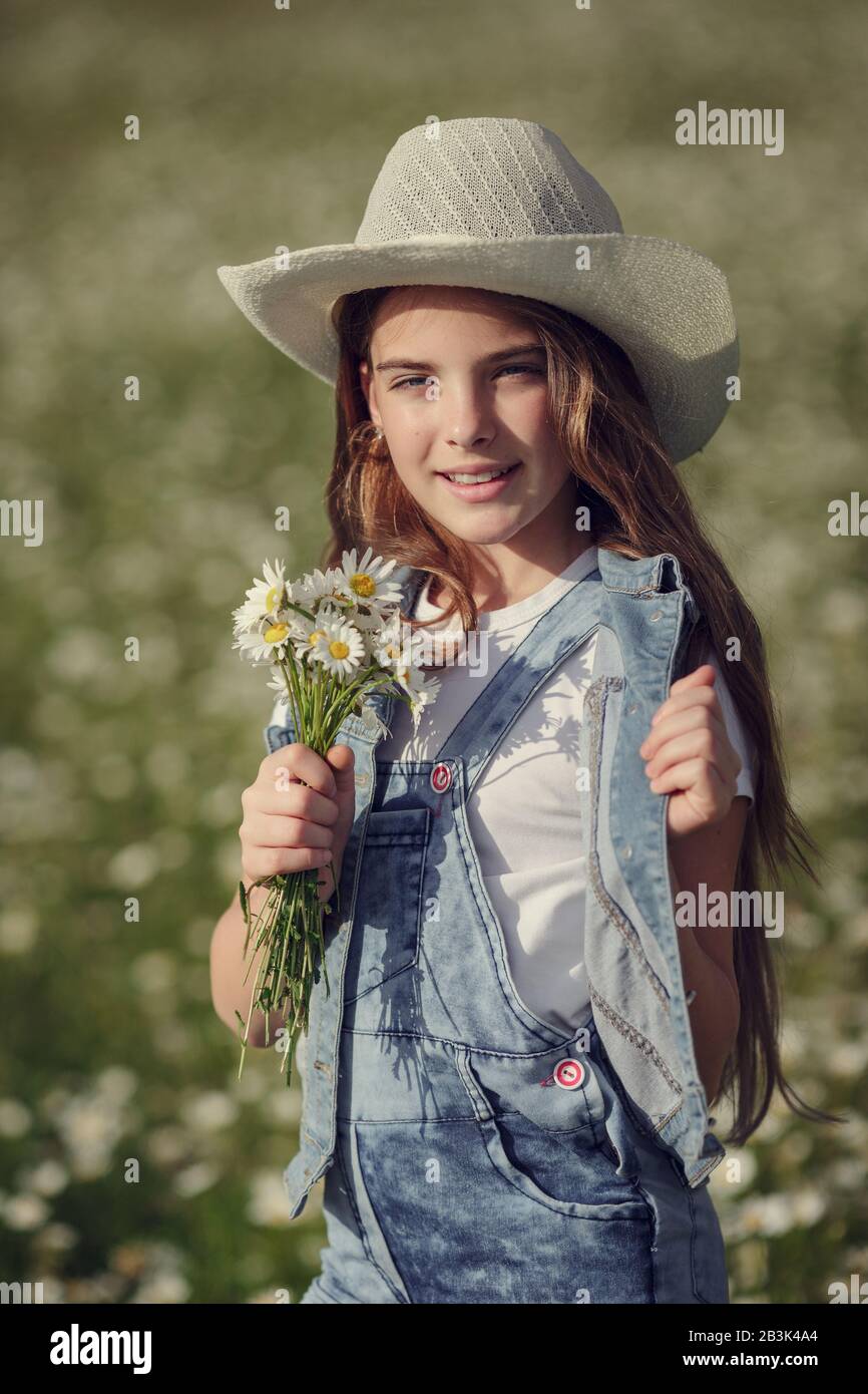 Bambina in un campo di fiori a margherita. Teen ragazza in cappello e abito  gode primavera in Daisy Field. Il concetto e l'idea di un'infanzia felice  Foto stock - Alamy
