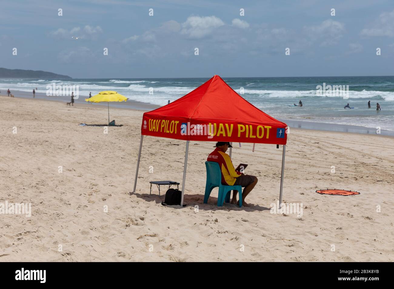 UAV drone pilota sulla spiaggia di lennox Head a NSW utilizzato per avvistare squali vicino alla riva, nuovo Galles del Sud, Australia Foto Stock