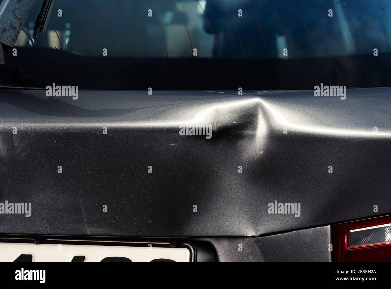 Un'ammaccatura nel corpo di un'auto d'argento Foto Stock