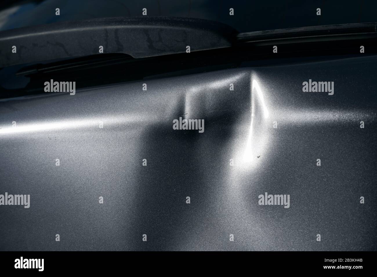 Un'ammaccatura nel corpo di un'auto d'argento Foto Stock