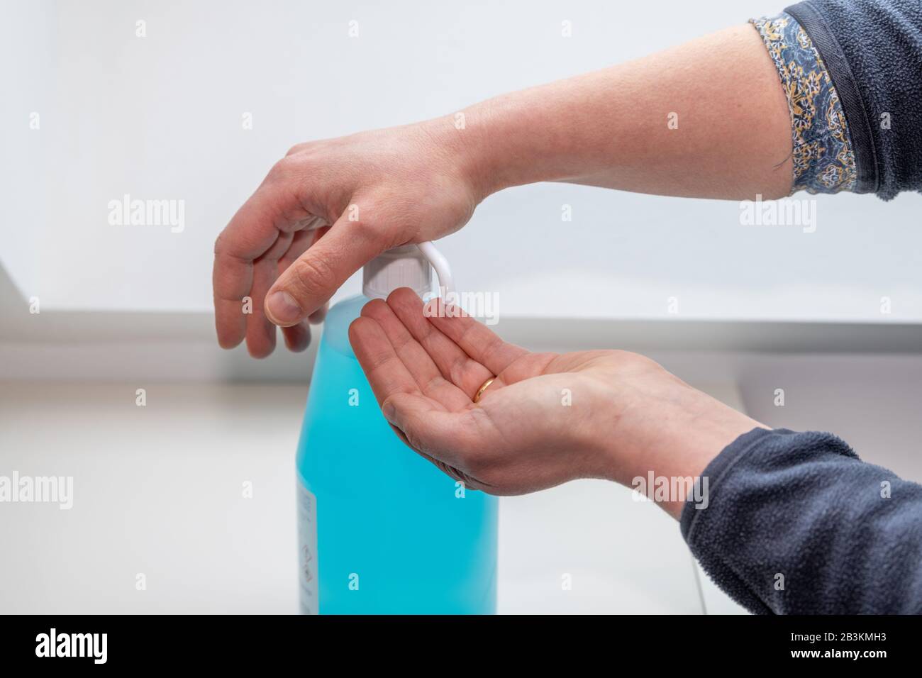 Donna che lava le mani usando gel idroalcolico, per prevenire la malattia Foto Stock