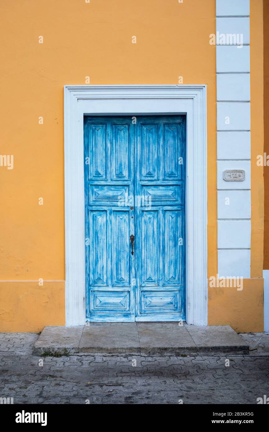 Una porta blu in una casa giallo-oro con lo stile geometrico art deco. Una tradizionale casa messicana in stile spagnolo degli anni '20 a Merida, Messico. Foto Stock