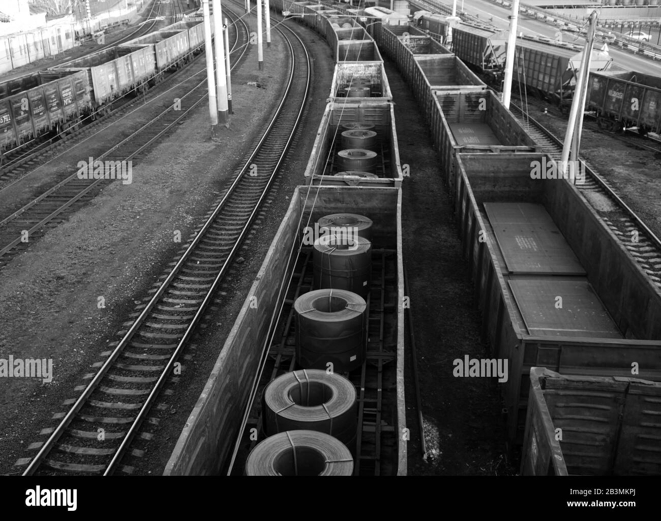 Si tratta di una vista che si affaccia sui treni merci e sulle rotaie. Uno dei treni merci trasporta merci dell'industria del metallo. Foto Stock