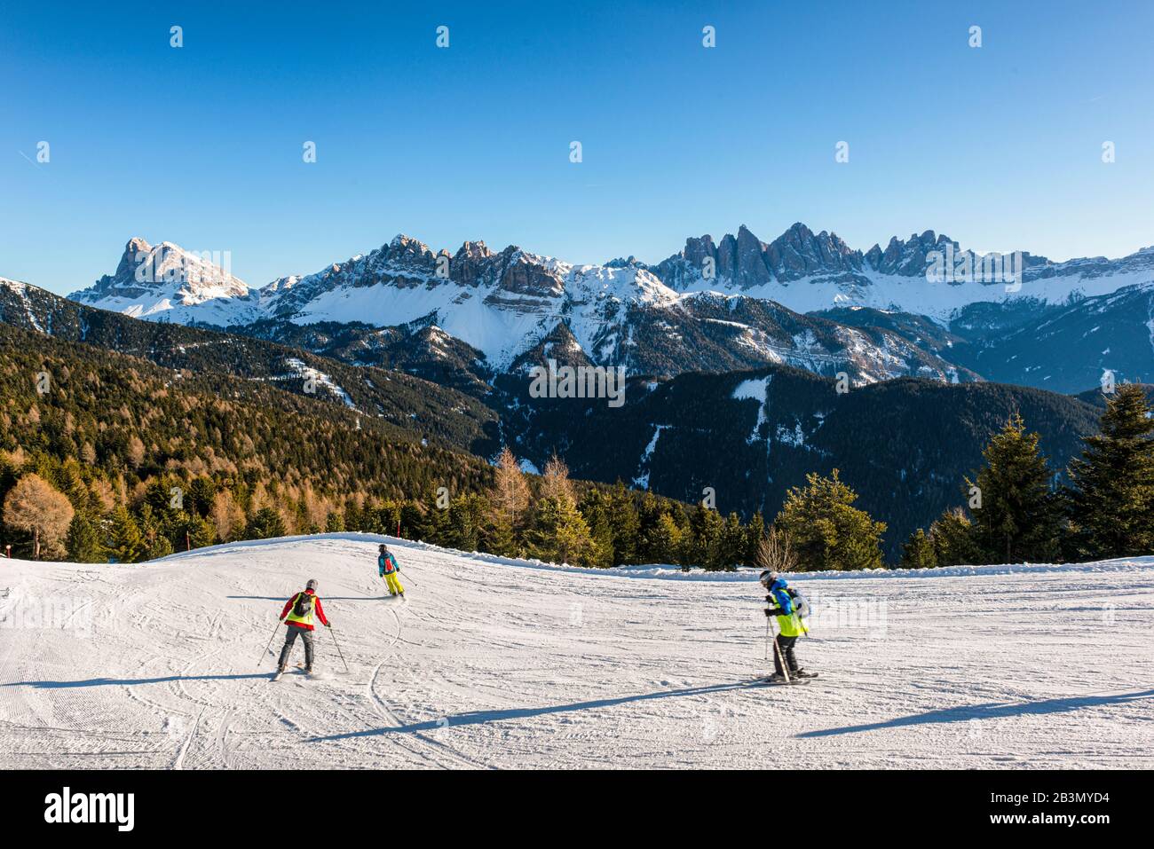 Italia Trentino Alto Adige - S.Andrea - piste da sci sul Plose in inverno con gli sciatori. Sullo sfondo le Odle e Sass de Putia dominano la valle che porta al Passo delle Erbe. Foto Stock