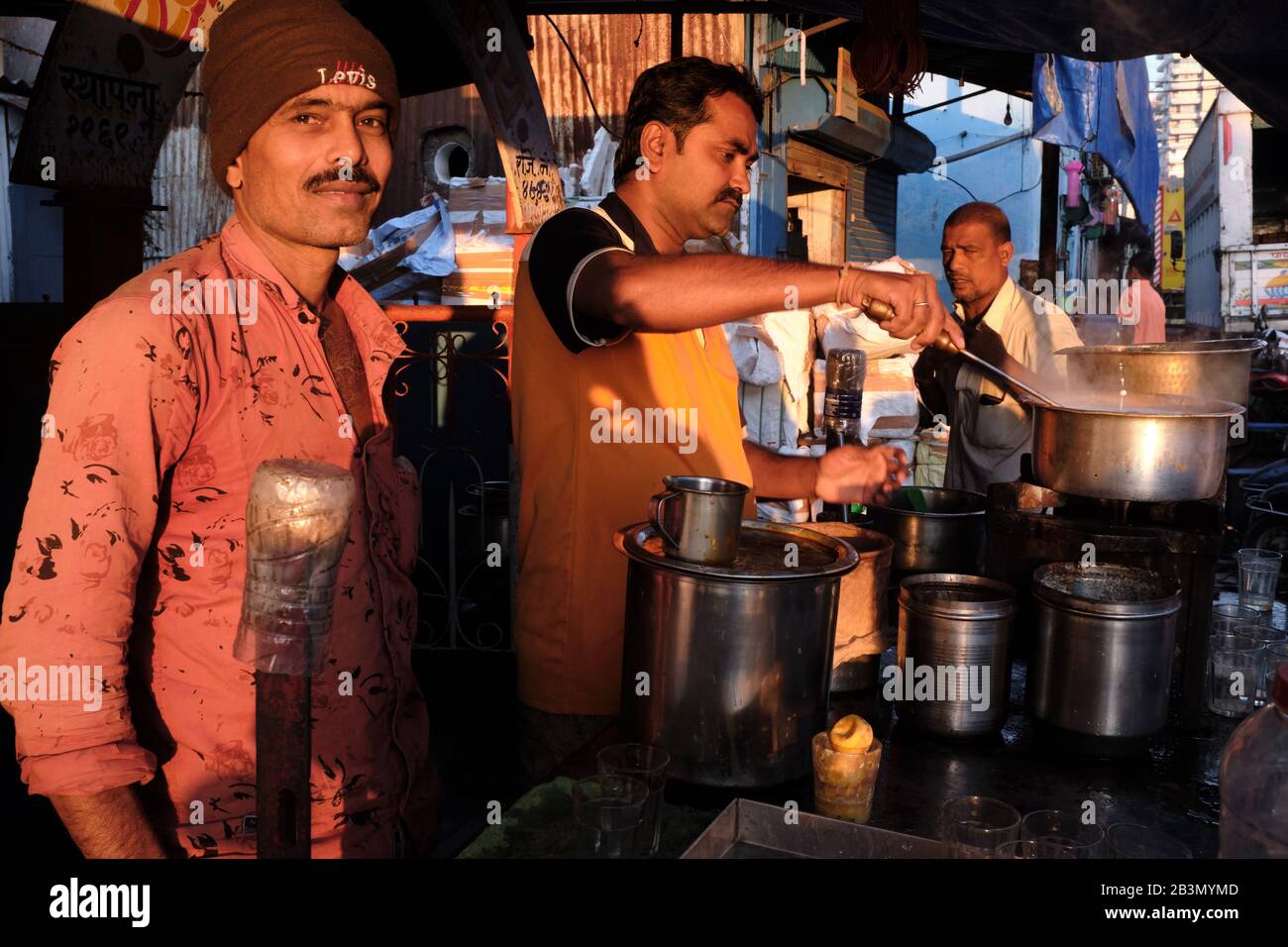 La calda luce del mattino presto splende su una stalla per il tè all'aperto a Sassoon Docks, Colaba, Mumbai (Bombay), India Foto Stock