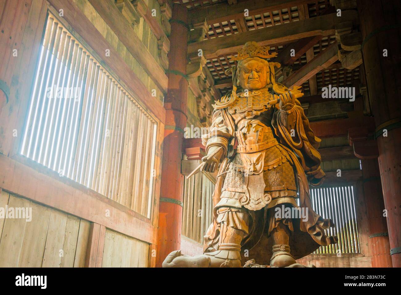 Statua in legno di Koumokuten, un guardiano all'interno della Sala del Grande Buddha (il Daibutsu-den), la parte del tempio di Todai-ji che ospita il Grande Bud Foto Stock