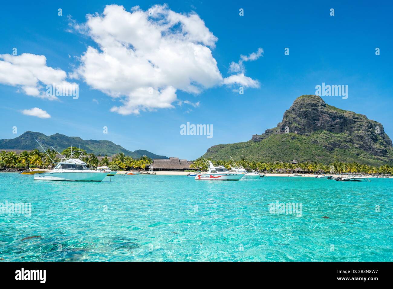 Barche nel mare turchese che circonda la spiaggia di sabbia bianca, le Morne Brabant, quartiere del fiume Nero, Mauritius, Oceano Indiano, Africa Foto Stock