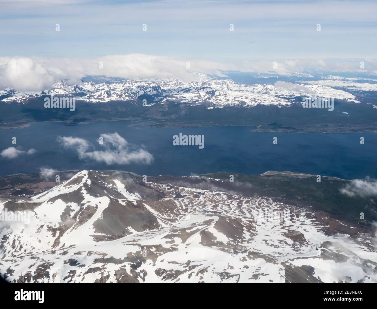 Una vista aerea delle Ande innevate che circondano il canale di Beagle, Argentina, Sud America Foto Stock