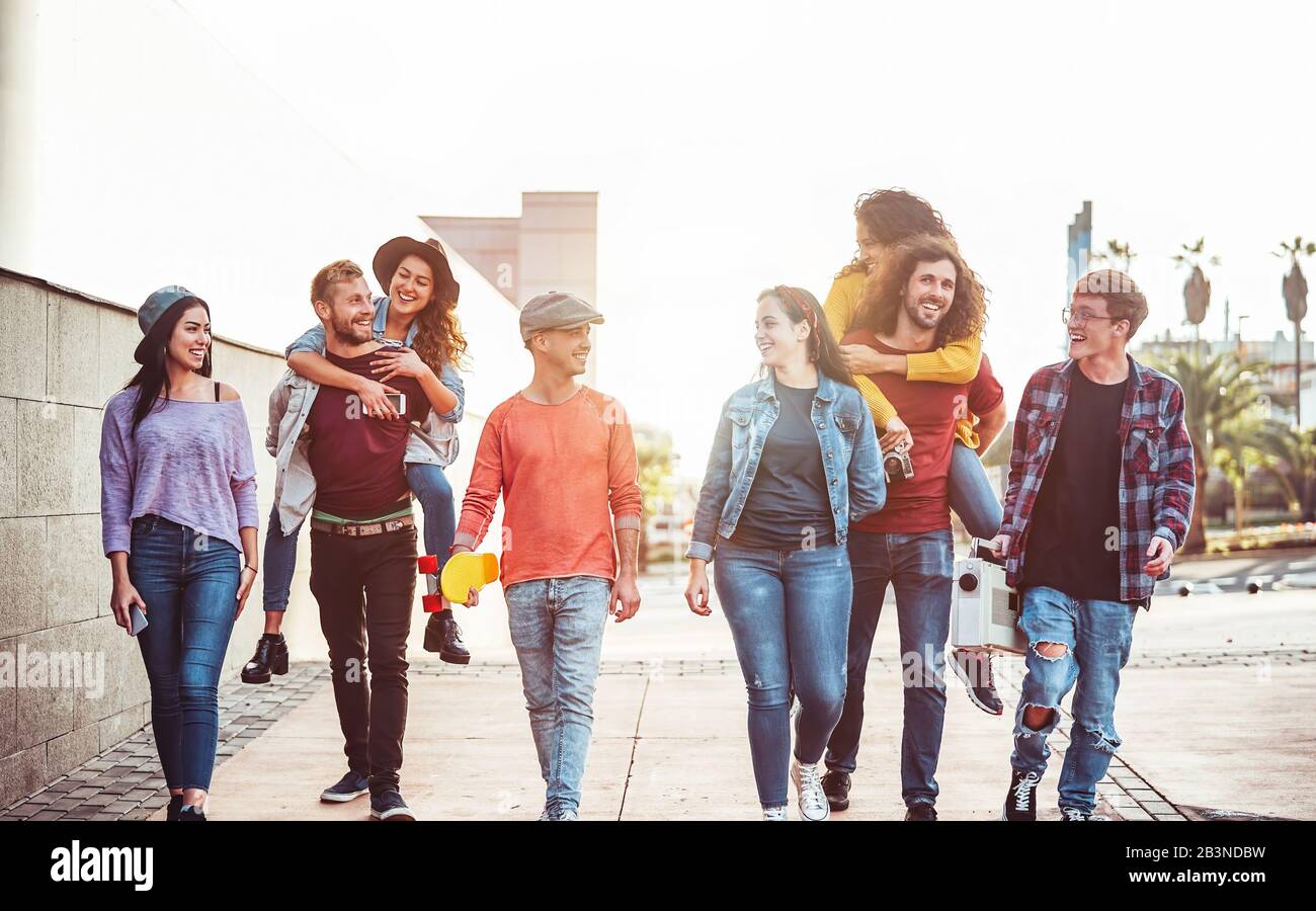 Gruppo di amici felice avendo divertimento outdoor - Giovani piggybacking ridendo e camminare insieme nel centro della città Foto Stock