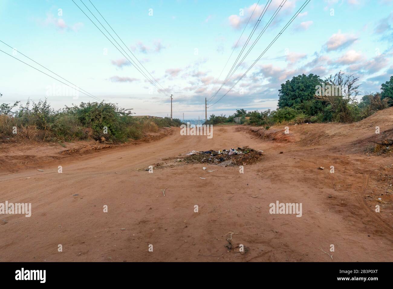 Strada di sabbia con rifiuti nel mezzo di esso in Mozambico, Africa Foto Stock