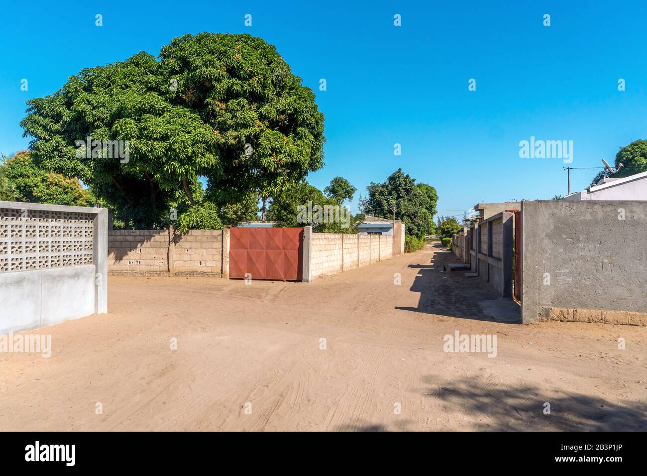 Strada sabbiosa di quartiere africano a Zimpato, Maputo, Mozambico Foto Stock