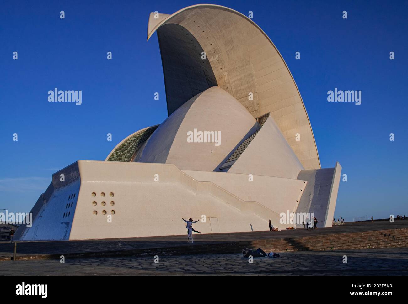 Tenerife/Spagna; 27 dicembre 2019: Auditorium Adan Martin, con luce del tramonto e persone che interagiscono intorno, Santa Cruz di Tenerife, Isole Canarie Foto Stock
