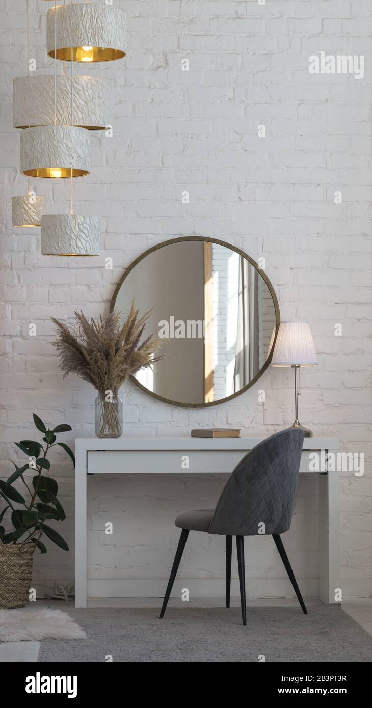 Moderna sedia in velluto grigio, scrivania, specchio rotondo, lampada da  tavolo e accessori per la casa con spazio per la copia Foto stock - Alamy