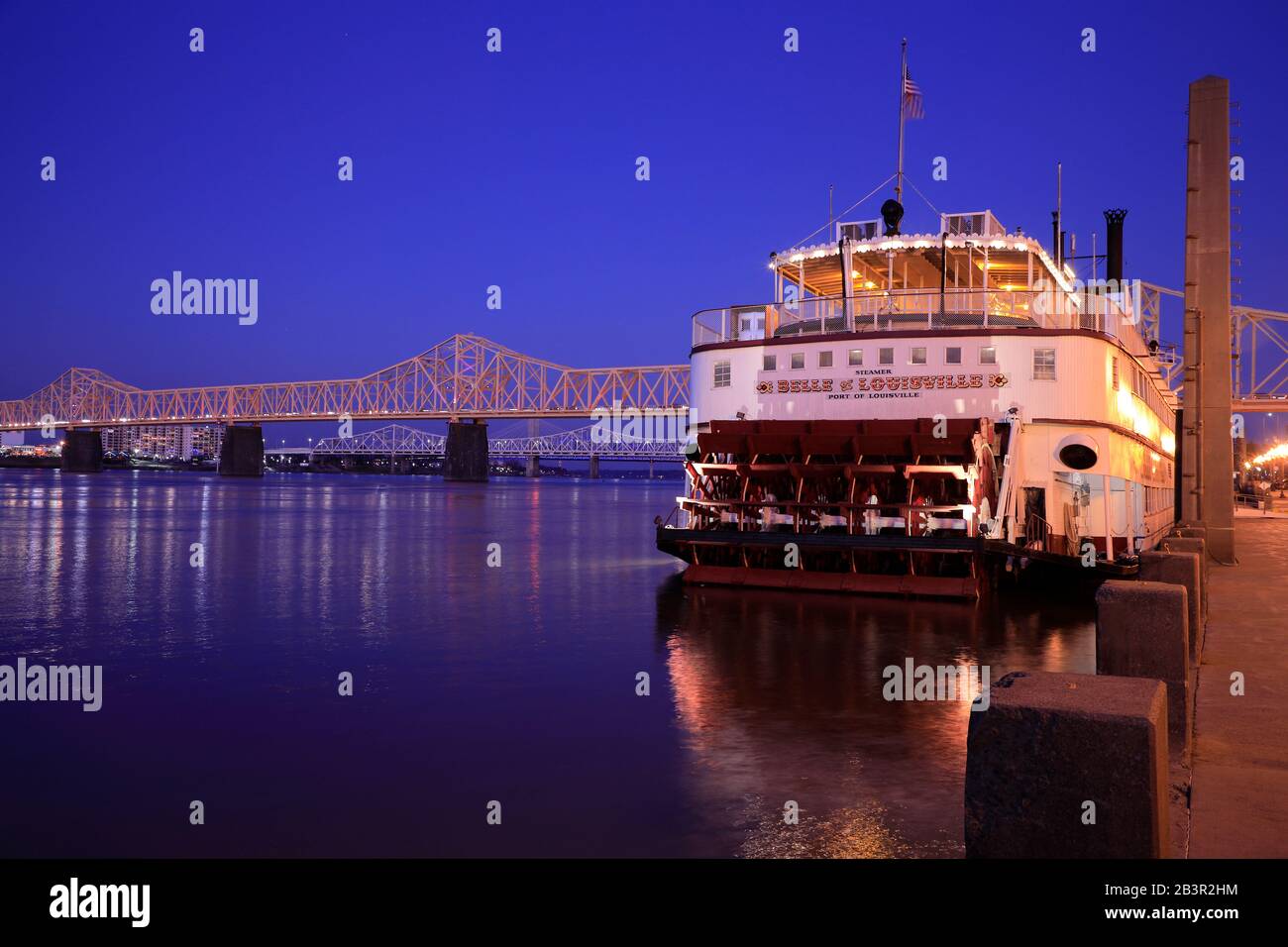 Vista al crepuscolo della storica nave fluviale a pale della Belle of Louisville che attracca sulla riva del Louisville Waterfront Park con il fiume Ohio e il George Rogers Clark Memorial Bridge nel retro.Louisville.Kentucky.USA Foto Stock